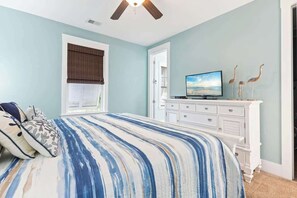 A bedroom with a bed, a television, a dresser, and a window with a view. - Madiera Magic Retreat (North Myrtle Beach)