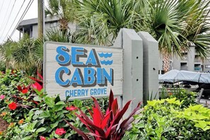 A wooden sign with the text 'SEA CABIN CHERRY GROVE' indicating the name of a lodging establishment. - Cherry Grove Retreat (North Myrtle Beach)