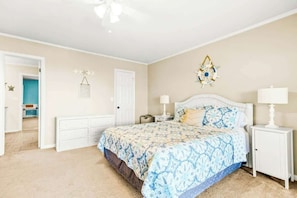 A bedroom with a bed, bedside tables, a white wardrobe, and a door leading to another room. - Coastal Comforts Retreat (Surfside Beach)