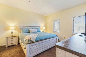 A bedroom with a bed, bedside tables, lamps, and a window with blinds. - Beaches and Birdies Retreat (North Myrtle Beach)