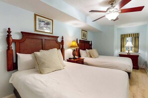 A hotel room with two beds, a ceiling fan, and a window with curtains. - Bahama Sands Unit 0508 (North Myrtle Beach)