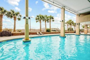A swimming pool with lounge chairs and palm trees. - Bahama Sands Unit 0508 (North Myrtle Beach)