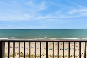 A beach view from a balcony with a railing, sandy beach, and ocean. - Ocean Park Resort 1222 (Myrtle Beach)