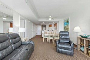 Ein Hotelzimmer mit Sofa, Sessel, Esstisch und Stühlen.