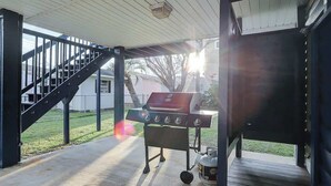Un espacio al aire libre techado con una parrilla y una escalera.