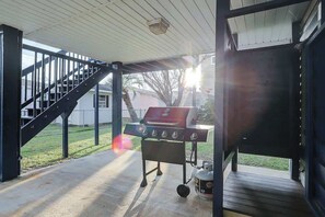 Ein überdachter Außenbereich mit Grill und Treppe.