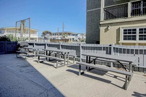 Picknicktische draußen und ein Gebäude mit einem Balkon.