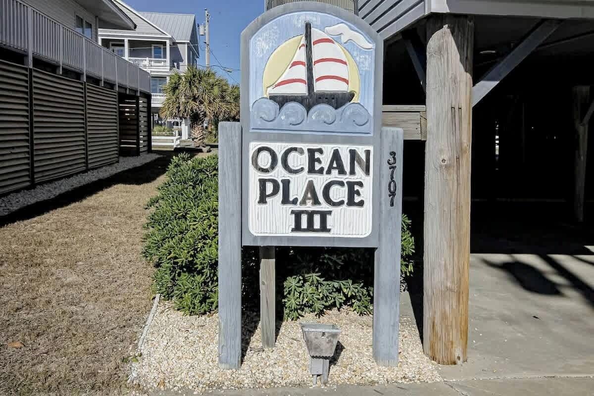 A sign for 'Ocean Place III' with a sailboat graphic.