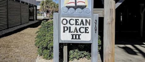 Une enseigne pour « Ocean Place III », avec une illustration représentant un voilier.