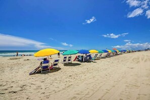 A beach with rows of beach chairs and umbrellas. - Caribbean Resort and Villas 1107 (Myrtle Beach)