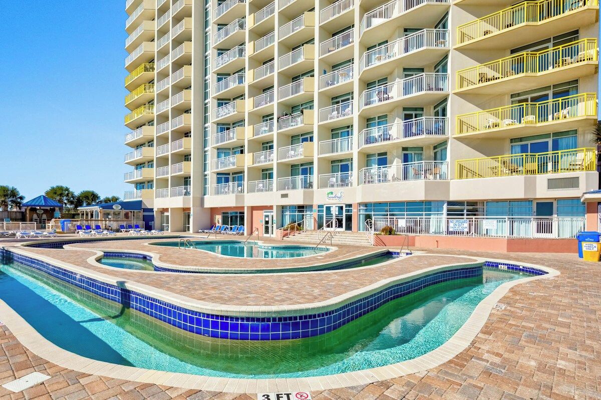 A multi-story hotel with a pool area featuring a wavy design.