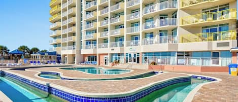 A multi-story hotel with a pool area featuring a wavy design.