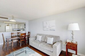 A living room with a sofa, chairs, a coffee table, a lamp, and a painting on the wall. - Bay Watch Unit 1221 Condo (North Myrtle Beach)