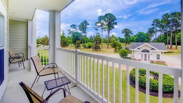 A covered porch with outdoor seating and a view of a residential area with trees and a house. - *1001 World Tour 206 (Myrtle Beach)