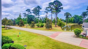 A residential area with a road, a pond, and a house with a porch. - *1001 World Tour 206 (Myrtle Beach)