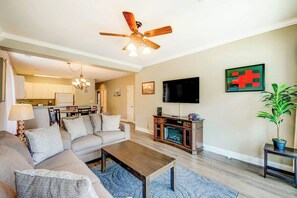 Ein Wohnzimmer mit einer Sofagarnitur, einem Couchtisch, einem Fernseher und einem Kamin.
