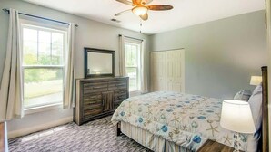A bedroom with a bed, dresser, ceiling fan, and a window with curtains. - *1001 World Tour 206 (Myrtle Beach)