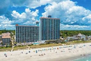 A beachfront hotel with multiple high-rise buildings, a sandy beach, and a swimming pool. - Caribbean Resort 525 (Myrtle Beach)