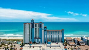 A high-rise hotel with multiple floors, a pool area, and a view of the ocean. - Caribbean Resort 525 (Myrtle Beach)