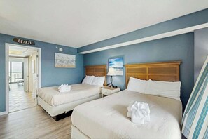 A hotel room with two beds, a wooden headboard, a painting, and a sign indicating the room is on the beach. - Caribbean Resort 525 (Myrtle Beach)
