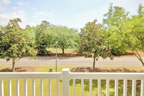 A view from a porch with a white railing, overlooking a street lined with trees and a street lamp. - 1017 World Tour Unit 204 (Myrtle Beach)