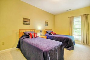 A room with two beds, a nightstand, a lamp, and a window with curtains. - 1017 World Tour Unit 204 (Myrtle Beach)