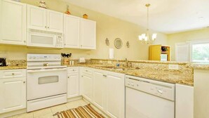 A kitchen with white cabinets, a microwave, stove, and dishwasher. - 1017 World Tour Unit 204 (Myrtle Beach)