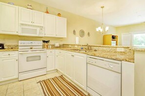 A kitchen with white cabinets, a microwave, stove, and dishwasher. - 1017 World Tour Unit 204 (Myrtle Beach)