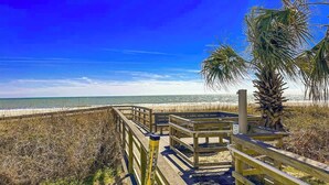 A wooden boardwalk leading to a beach with a clear sky. - St Clement's Unit 409 (Myrtle Beach)