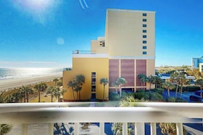 Ein Hotel mit Blick auf den Strand, einem Pool und einem Parkplatz.