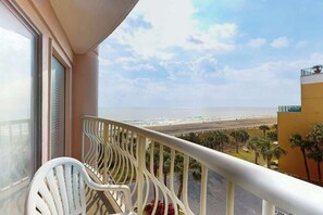 Uma varanda com vista para a praia e o oceano.