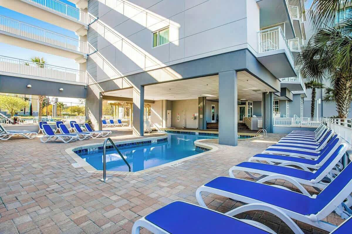 A pool area with lounge chairs and a swimming pool.