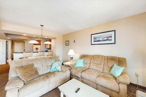 A living room with two sofas, a coffee table, and a dining area in the background. - Harbourgate Unit 132 (North Myrtle Beach)