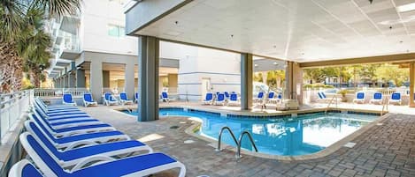 A pool area with lounge chairs and a swimming pool.