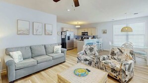 A living room with a sofa, armchairs, a coffee table, and a ceiling fan. - The Tickled Pink Retreat (Murrells Inlet)
