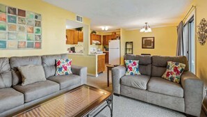 A living room with two sofas, a coffee table, and a kitchen in the background. - Myrtle Beach Resort B-229 (Myrtle Beach)