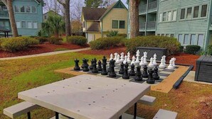 A chessboard set up on a picnic table in a residential area with houses in the background. - Myrtle Beach Resort B-229 (Myrtle Beach)