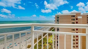 Ein Strandhotel mit Balkonen mit Blick auf den Ozean und den Strand.
