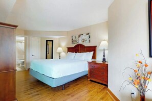 A bedroom with a bed, wooden dresser, and a vase with flowers. - Carolinian Beach Resort 1734 (Myrtle Beach)