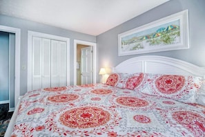 Ein Schlafzimmer mit einem Bett, einer Tür und einer Wandleuchte.