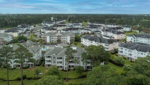 A residential area with multiple two-story houses, each with a front lawn and driveway. - Magnolia Pointe Unit 305 (Myrtle Beach)