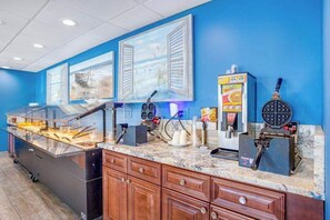 Ein Buffetbereich mit Theke, Speisenpräsentation und einem Waffelautomat.