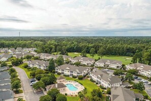 A residential area with multiple two-story houses, a golf course, and a swimming pool. - Legends Resort - Montrose C (Myrtle Beach)