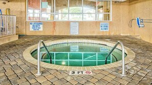 Pequena piscina interior com sinalização de profundidade de 3 pés, piso revestido de azulejos e avisos sobre ausência de salva-vidas e área rasa.