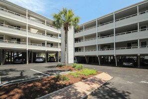 Eine mehrstöckige Parkgarage mit einem begrünten Innenhof und einer Palme.