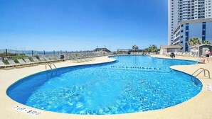 A pool area with a clear blue pool, a lifeguard stand, and a high-rise building in the background. - Myrtle Beach Resort B-349 (Myrtle Beach)