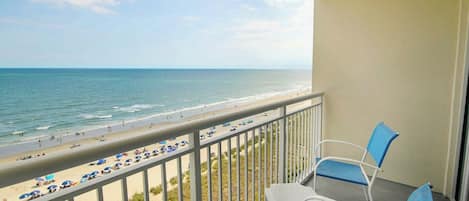 Ein Balkon mit Blick auf Strand und Meer.