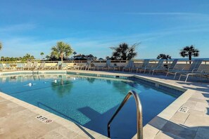 A swimming pool with lounge chairs and palm trees. - Ocean Creek Plantation D-1 (Myrtle Beach)