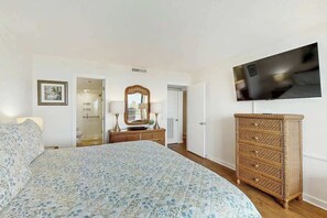 A bedroom with a bed, a dresser, a television, and a mirror. - Ocean Creek Plantation D-1 (Myrtle Beach)