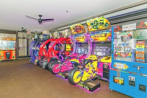A row of arcade games with various titles and vibrant colors. - Ocean Reef Resort 723 (Myrtle Beach)
